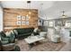 Stylish living room featuring a wood accent wall, comfortable seating, and an open layout connecting to the kitchen at 112 Lake Butler Ave, Haines City, FL 33844