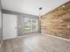 Modern living space with stylish wood accent wall, neutral tile floors, and ample natural light from a large window at 112 Lake Butler Ave, Haines City, FL 33844
