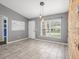 Inviting open-concept space with a wood accent wall, neutral tile floors, and a view of the front yard at 112 Lake Butler Ave, Haines City, FL 33844