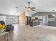 Open-concept living space with a modern kitchen island, wood accent wall, and neutral tile flooring at 112 Lake Butler Ave, Haines City, FL 33844
