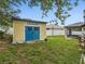 Bright yellow shed with blue doors in a well-maintained backyard at 112 Lake Butler Ave, Haines City, FL 33844