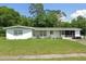 An exterior shot of a charming one-story home with a screened-in porch and a well-maintained lawn at 115 Lake Dot Dr, Sanford, FL 32773