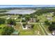Expansive aerial view of a private estate with a tennis court and lake at 12434 Sullivan Rd, Clermont, FL 34715