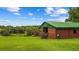 Exterior view of the barn with a metal roof, grassy area, picnic table, and trees at 12434 Sullivan Rd, Clermont, FL 34715