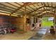 Interior view of the barn with stalls, equipment and a view of the surrounding pasture at 12434 Sullivan Rd, Clermont, FL 34715