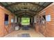 Interior view of the barn with multiple wooden stalls and a dirt floor at 12434 Sullivan Rd, Clermont, FL 34715