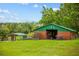 Exterior view of the barn with a metal roof and green grassy area at 12434 Sullivan Rd, Clermont, FL 34715