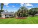 Home exterior with lush lawn, palm trees, and well-maintained landscaping at 12434 Sullivan Rd, Clermont, FL 34715
