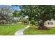Charming home with a well-manicured lawn, mature tree, and inviting walkway at 12434 Sullivan Rd, Clermont, FL 34715