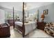Comfortable main bedroom showcasing a four-poster bed and great natural lighting at 12434 Sullivan Rd, Clermont, FL 34715