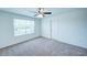 Bright bedroom with a ceiling fan, neutral carpet, and a window providing natural light at 1303 Congo Ct, Kissimmee, FL 34759