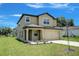 Two-story home with tan siding, a covered front entry and two-car garage at 1303 Congo Ct, Kissimmee, FL 34759