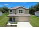 Two-story home showcasing a neutral exterior, covered porch, and attached two-car garage at 1303 Congo Ct, Kissimmee, FL 34759