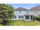 Rear exterior of the house with an open patio, several windows, and greenery in the backyard at 137 Drayton Ave, Davenport, FL 33837