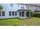 View of the home's rear exterior with a covered patio and a modest lawn at 137 Drayton Ave, Davenport, FL 33837