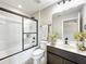 Bathroom with a modern vanity, dark cabinets, a glass-enclosed shower over tub, and tiled floors at 137 Drayton Ave, Davenport, FL 33837