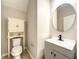 Half bathroom with a vanity, a decorative mirror, and a cabinet over the toilet at 137 Drayton Ave, Davenport, FL 33837