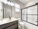Bathroom features a shower over tub with a black frame, a dark vanity, and a white toilet at 137 Drayton Ave, Davenport, FL 33837