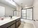 Bathroom featuring a modern vanity, dark cabinets, a glass-enclosed shower over tub, and tiled floors at 137 Drayton Ave, Davenport, FL 33837