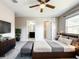 Well lit bedroom with a ceiling fan, a television, a bench, and an ensuite bathroom at 137 Drayton Ave, Davenport, FL 33837