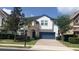 Charming two-story home featuring stone accents, blue garage door, and a well-maintained landscaped front yard at 137 Drayton Ave, Davenport, FL 33837