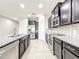 Modern kitchen featuring granite countertops, stainless steel appliances, and dark wood cabinetry at 137 Drayton Ave, Davenport, FL 33837