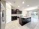 Modern kitchen with an island, granite countertops, stainless steel appliances, and dark wood cabinets at 137 Drayton Ave, Davenport, FL 33837