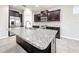 Modern kitchen with an island, granite countertops, stainless steel appliances, and dark wood cabinets at 137 Drayton Ave, Davenport, FL 33837