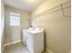 Functional laundry room with a washer, dryer, shelving and a well-lit window at 137 Drayton Ave, Davenport, FL 33837