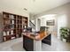 Elegant office space with built-in bookshelves, a large executive desk, and neutral decor at 137 Drayton Ave, Davenport, FL 33837