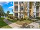 Condo building exterior view with landscaped walkway, palm trees, and lake access at 1400 Lake Shadow Cir # 10104, Maitland, FL 32751