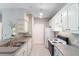 Kitchen featuring white cabinets, neutral countertops, stainless sink, and modern appliances at 1400 Lake Shadow Cir # 10104, Maitland, FL 32751