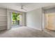 Open living space with balcony access, neutral carpeting, and in-wall shelving at 1400 Lake Shadow Cir # 10104, Maitland, FL 32751