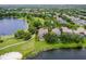 A scenic aerial view of the home, backing onto a tranquil lake and surrounded by verdant trees, creating a peaceful setting at 14038 Bluebird Park Rd, Windermere, FL 34786