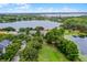 A scenic aerial view showcases a lakeside home surrounded by lush greenery, highlighting its serene and private location at 14038 Bluebird Park Rd, Windermere, FL 34786