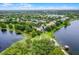 An elevated view of a neighborhood near a lake reveals well-maintained homes surrounded by lush foliage, creating a peaceful community at 14038 Bluebird Park Rd, Windermere, FL 34786