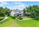 An expansive backyard with lush green lawn, decorative shrubs, and a screened-in pool offers an outdoor retreat at 14038 Bluebird Park Rd, Windermere, FL 34786
