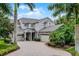 Stunning two-story home with lush landscaping and circular brick driveway and a three-car garage at 14038 Bluebird Park Rd, Windermere, FL 34786