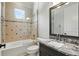 Bathroom featuring a granite vanity top and shower with decorative tile work at 1425 Dunbrooke Loop, Longwood, FL 32779
