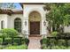 Elegant front entrance with arched doorway, double doors, and manicured landscaping at 1425 Dunbrooke Loop, Longwood, FL 32779