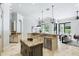 Open kitchen with island and stainless appliances adjoining living room with backyard views at 1425 Dunbrooke Loop, Longwood, FL 32779