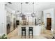 Bright, white kitchen featuring stainless appliances, stone countertops and a center island with chairs at 1425 Dunbrooke Loop, Longwood, FL 32779