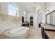 Elegant bathroom with soaking tub, granite counters, and access to a large walk-in closet at 1425 Dunbrooke Loop, Longwood, FL 32779