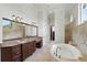 Luxurious main bathroom featuring double vanity, soaking tub, and neutral stone accents at 1425 Dunbrooke Loop, Longwood, FL 32779