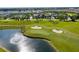 Aerial view of a golf course with a lake, sand traps, and perfectly manicured green at 1439 Moon Valley Dr, Davenport, FL 33896