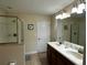 Bright bathroom featuring a double sink vanity, walk-in shower with glass door and neutral tiled floors at 1439 Moon Valley Dr, Davenport, FL 33896