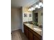 Bathroom featuring a double sink vanity with granite counters, decorative mirror, and tiled floors at 1439 Moon Valley Dr, Davenport, FL 33896