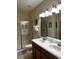 Bright bathroom featuring double sinks, a walk-in shower, and well-lit vanity at 1439 Moon Valley Dr, Davenport, FL 33896