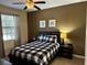 Cozy bedroom with a checkered comforter, ceiling fan, and warm ambient lighting at 1439 Moon Valley Dr, Davenport, FL 33896