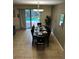 Dining room with seating for eight, chandelier, tile floor, and sliding glass doors overlooking pool at 1439 Moon Valley Dr, Davenport, FL 33896